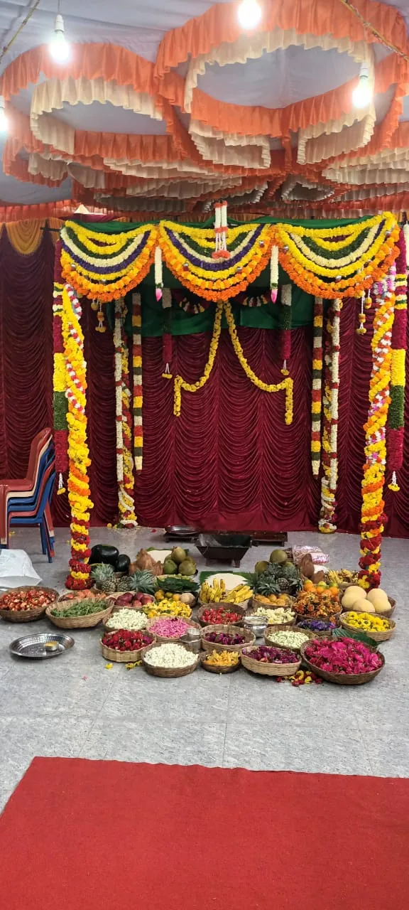 The mandapa hung in marigold garlands with the offerings for the day laid out in dishes across the floor in front of it