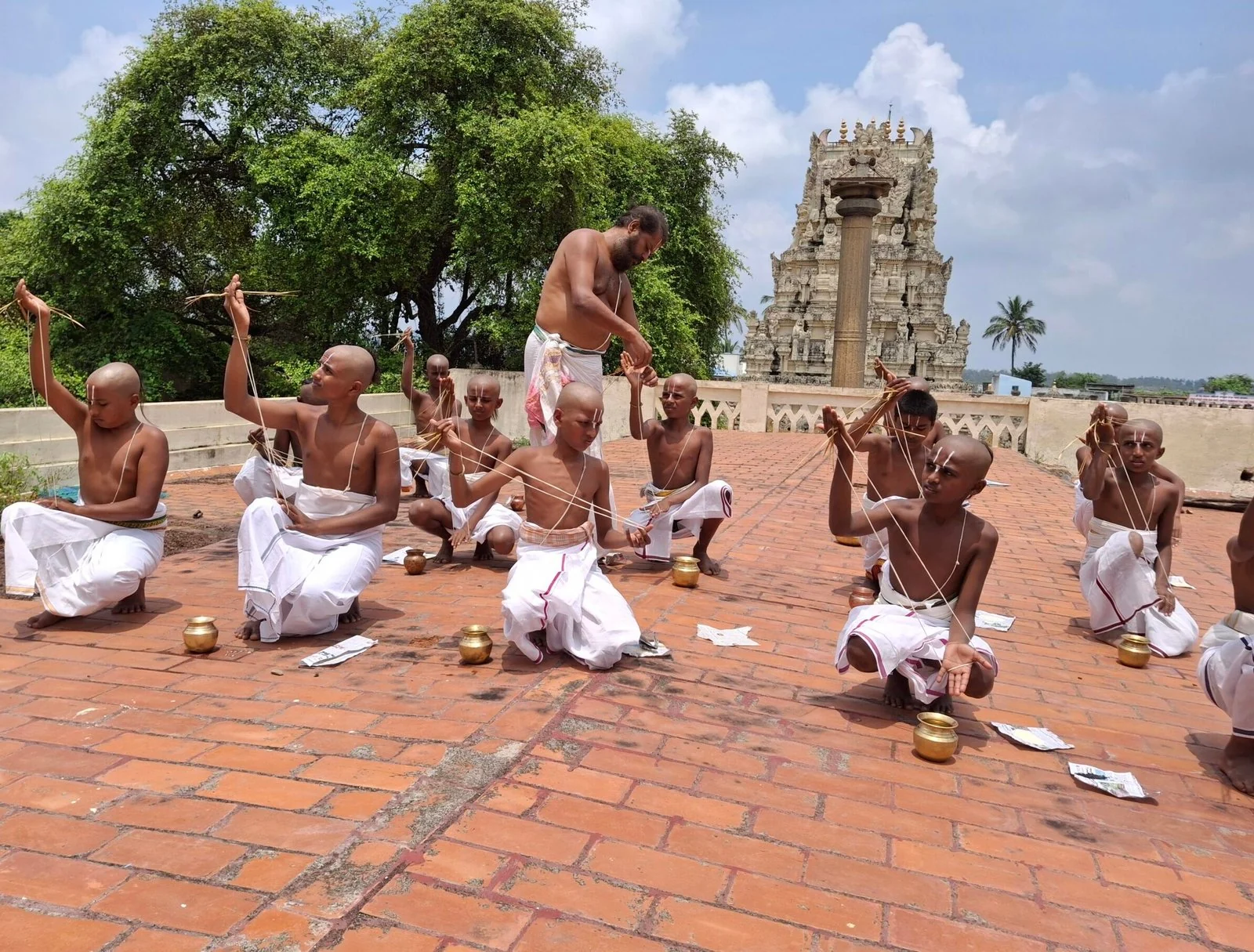 Gurukulam students seated on the temple terrace during Upakarma, with the gopuram behind them